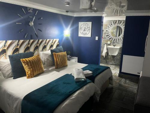 a bedroom with a large bed with a clock on the wall at Mitchell's Guesthouse in Parow