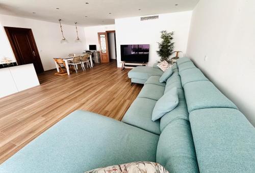 ein Wohnzimmer mit einem blauen Sofa im Wohnzimmer in der Unterkunft Casa con PISCINA y CINE in Paterna