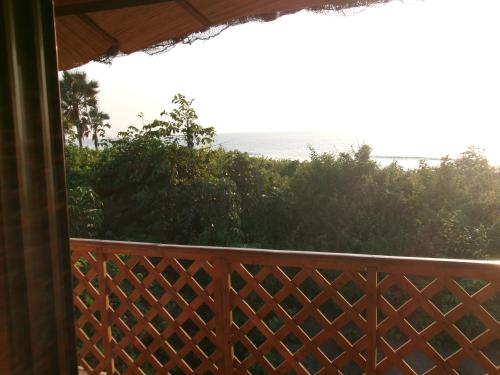 a balcony with a view of the ocean at About Time Lodge in Kartung