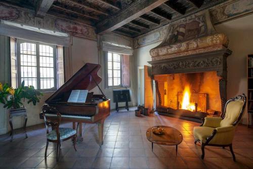 a living room with a piano and a fireplace at Lake Varese villa in Azzate