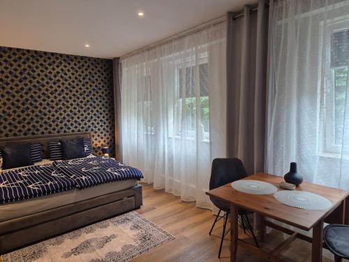 a bedroom with a bed and a table and a dining room at Zentroom studio apartment in Flensburg