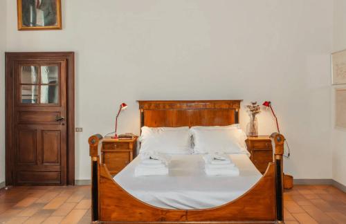 a bedroom with a wooden bed with two towels on it at Lake Varese villa in Azzate
