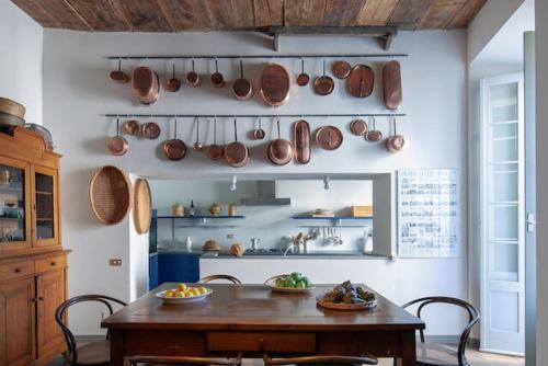 a kitchen with a table and pots and pans on the wall at Lake Varese villa in Azzate