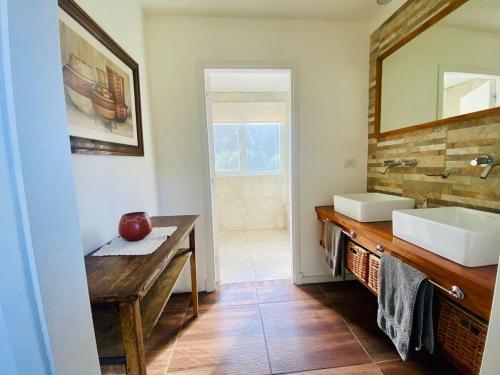 un bagno con due lavandini e uno specchio di CASA CALMA refugio en medio de la naturaleza de Acantilados y amantes del golf a Mar del Plata