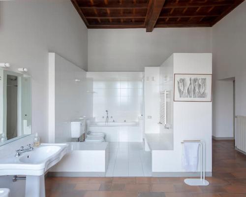 a white bathroom with a tub and a toilet and a sink at Lake Varese villa in Azzate