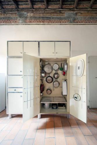a kitchen with white cabinets and pots and pans at Lake Varese villa in Azzate