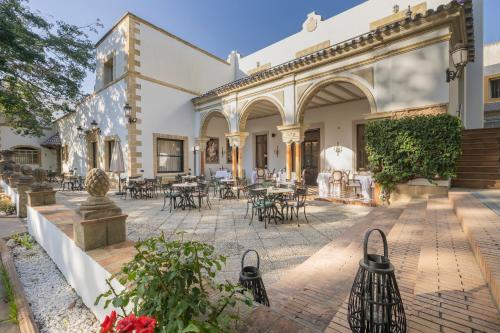 a courtyard with tables and chairs in a building at Soho Boutique Duques de Medinaceli - Adults Recommended in El Puerto de Santa María