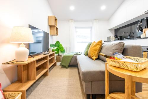 a living room with a couch and a tv at Charming Santo Antonio Roof top in Monção
