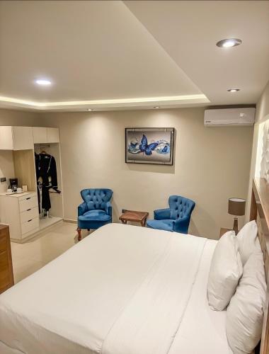 a hospital room with a bed and two blue chairs at Hotel Arthemisa in Dolores Hidalgo