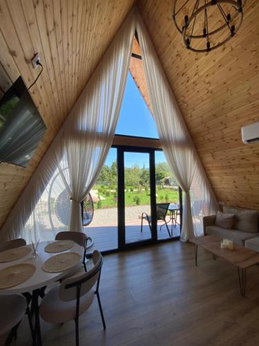 a living room with a table and chairs and a large window at Chalet Martvili in Martvili