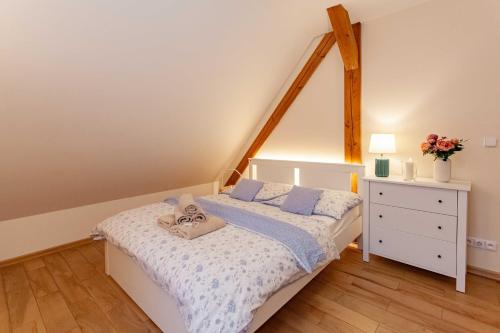 a bedroom with a white bed and a white dresser at Resort Mlýn Karolínka in Vranov nad Dyjí