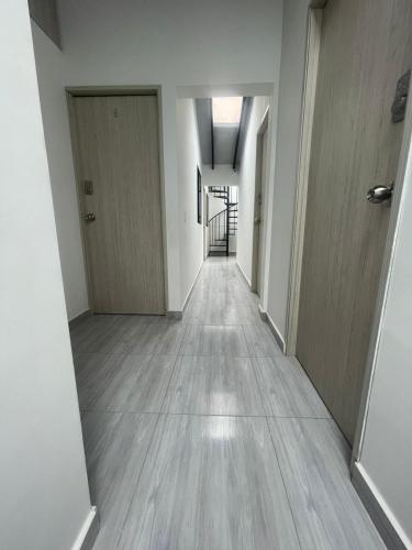 an empty hallway of an apartment with white walls and wooden floors at Hotel boutique Olaya 54 in Medellín