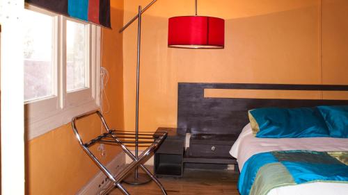 a bedroom with a bed and a red lamp at Happy House Hostel in Santiago