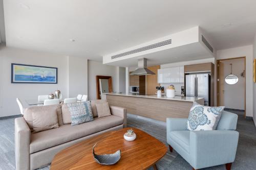 a living room with a couch and a table at Exclusive apartment- Rooftop pool in Cancún