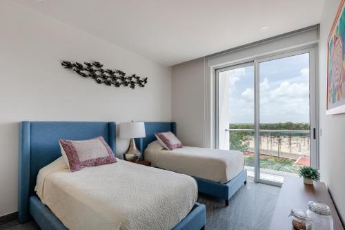two beds in a room with a window at Exclusive apartment- Rooftop pool in Cancún