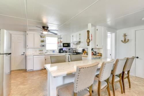a white kitchen with a table and chairs at 2 Mi to Public Beach Pet-Friendly Freeport Home! in Freeport