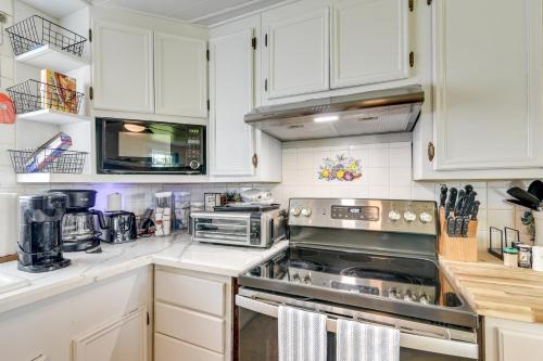a kitchen with white cabinets and stainless steel appliances at 2 Mi to Public Beach Pet-Friendly Freeport Home! in Freeport