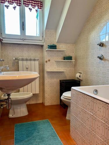 a bathroom with a sink and a toilet and a tub at Casa Costanza in Pescasseroli