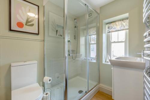 Un baño con ducha, inodoro y lavabo. en Swiftsure, en Lyme Regis