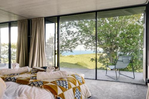 Un dormitorio con una cama y una gran ventana de cristal. en The Bunker - Ventnor, en Ventnor
