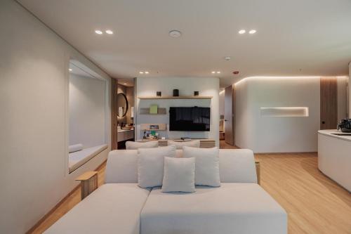 a living room with a white couch and a tv at Seissta Medellín in Medellín