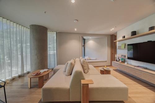a living room with a couch and a flat screen tv at Seissta Medellín in Medellín
