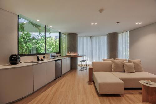 a living room with a couch and a kitchen at Seissta Medellín in Medellín