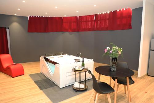 a living room with a hot tub and a table and chairs at La Suite Romantique in Rethel