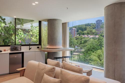 a living room with a couch and large windows at Seissta Medellín in Medellín