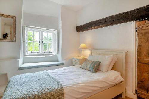 ein Schlafzimmer mit einem weißen Bett und einem Fenster in der Unterkunft Rose Cottage - Powerstock in Powerstock