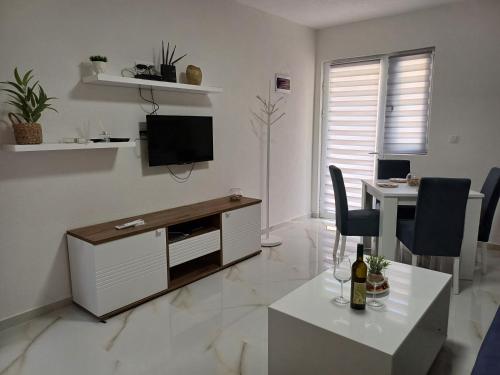 a white living room with a tv and a desk at Apartment Brijest-Kotor in Kotor