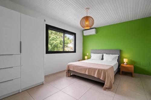 a green bedroom with a bed and a window at Villa Keyana in Ducos