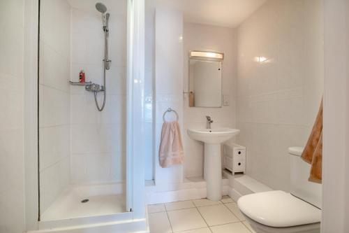 Un baño blanco con ducha y lavabo. en Maritime House Apartment, en West Bay