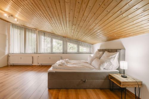 a bedroom with a large bed with a wooden ceiling at Exklusive große Ferienwohnung für 7 Personen, Parkplatz, Balkon, 3 Schlafzimmer in Bayreuth
