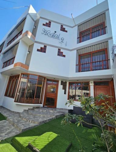 a building with a lawn in front of it at Hostal Siglo 21 in Tacna