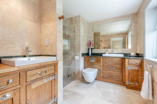 a bathroom with a sink and a toilet and a shower at Riverside Cottage - Wareham in Wareham