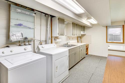 a large white kitchen with a washer and dryer at Walk to Spring Lake with Waterpark Family Retreat! in North Mankato