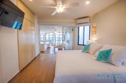 a bedroom with a bed and a ceiling fan at Luna Azul 8: Beachfront Paradise in Akumal in Akumal