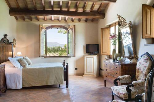 ein Schlafzimmer mit einem Bett, einem Fenster und einem Stuhl in der Unterkunft Assisi villa rental in Santa Maria degli Angeli