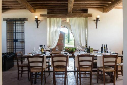ein Esszimmer mit einem langen Tisch mit Stühlen und Weinflaschen in der Unterkunft Assisi villa rental in Santa Maria degli Angeli