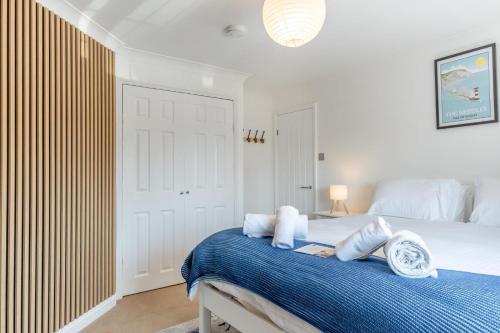 a bedroom with a bed with blue sheets and white pillows at No. 41 - Sandown in Sandown