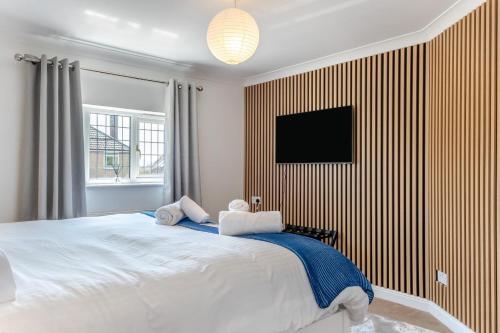 a bedroom with a large bed with a tv on the wall at No. 41 - Sandown in Sandown