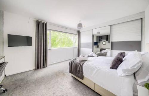 une chambre blanche avec un lit et une télévision à écran plat dans l'établissement Fawn House, à Olton