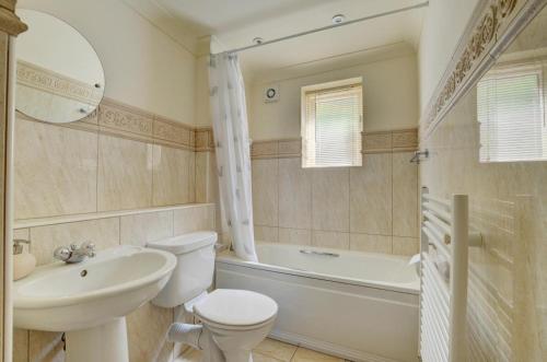 a bathroom with a toilet and a sink and a tub at 3 The Downs in Swanage