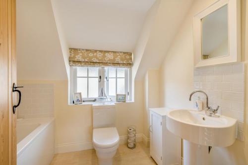 a bathroom with a sink and a toilet and a tub at Seascape - West Lulworth in West Lulworth