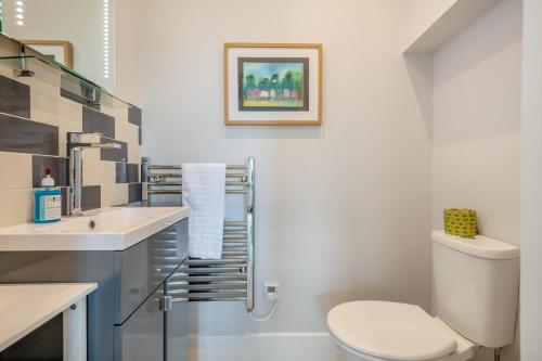 a white bathroom with a toilet and a sink at Homelands in Studland
