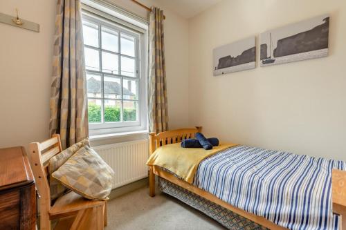 a bedroom with a bed and a window and a chair at Homelands in Studland