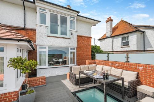 a patio of a home with a table and chairs at Homelands in Studland