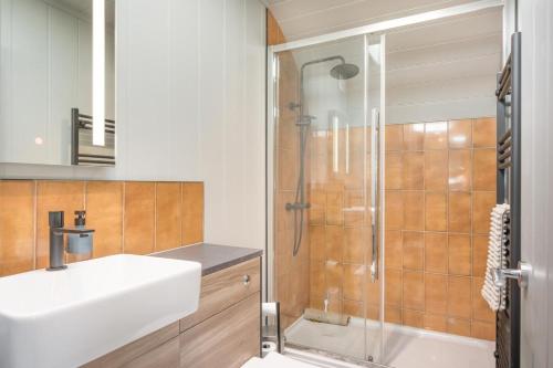 a bathroom with a white sink and a shower at Four Lakes Retreat In Three in Newport