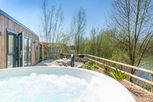 a bath tub on the patio of a house at Four Lakes Retreat In Three in Newport
